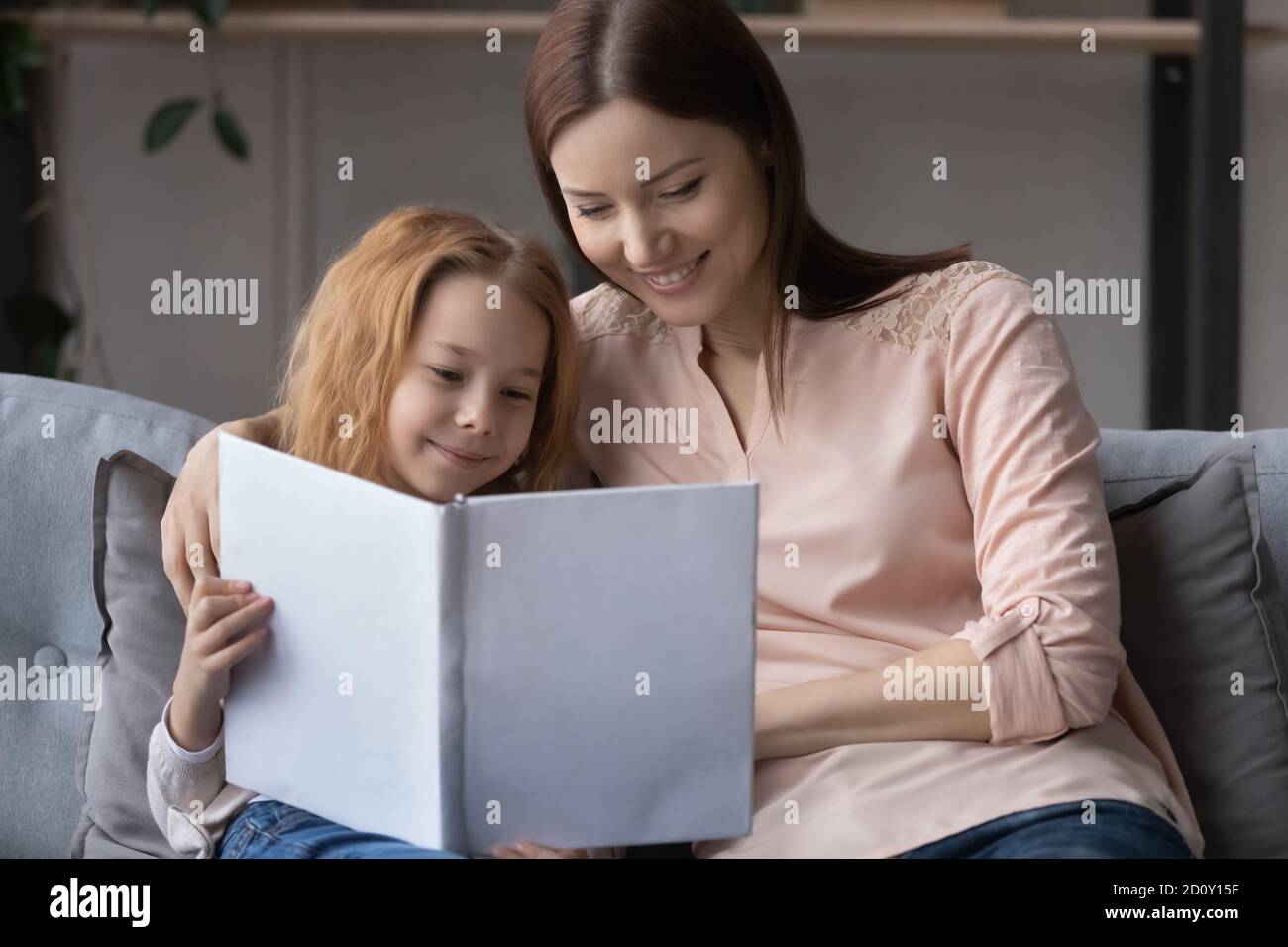 Mother and daughter read together hires stock photography and images