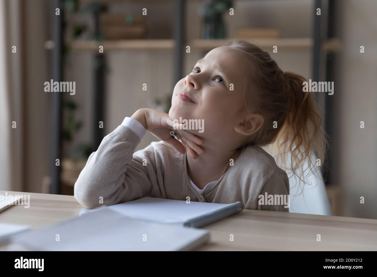 Close up funny dreamy little girl sitting at desk, studying Stock Photo ...