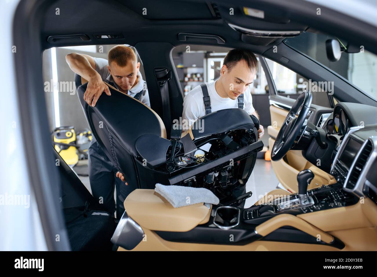 Two workers removes car seats for detailing Stock Photo Alamy