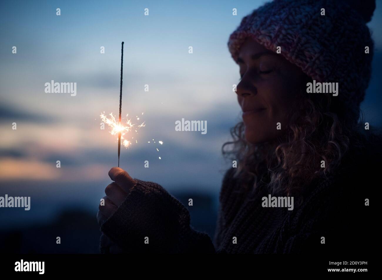 Celebration and hope future concept with beautiful woman portrait with fired sparkler in the dark of the night around - new year eve and celebration i Stock Photo