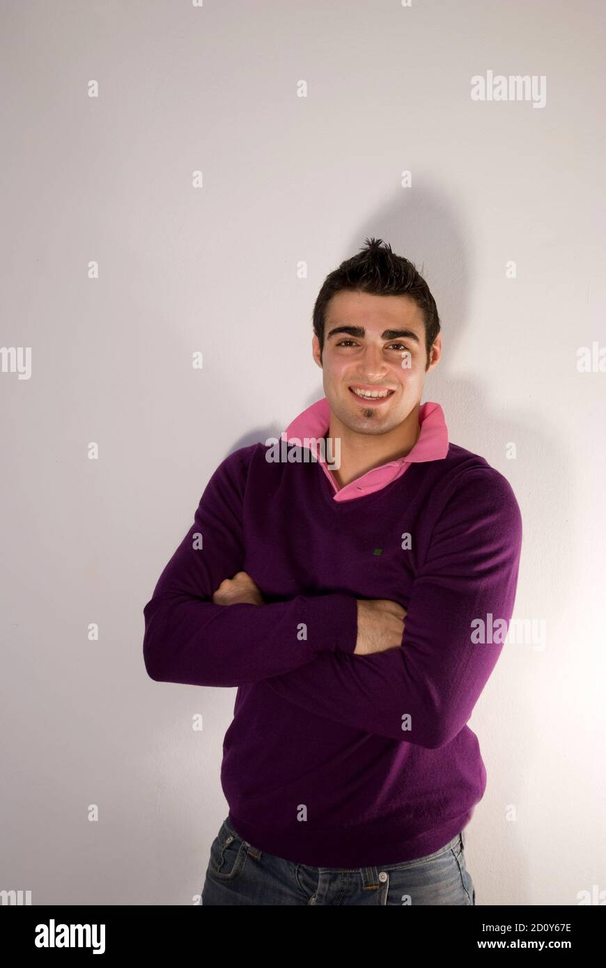Young man looking at the camera and crossing arms. Stock Photo