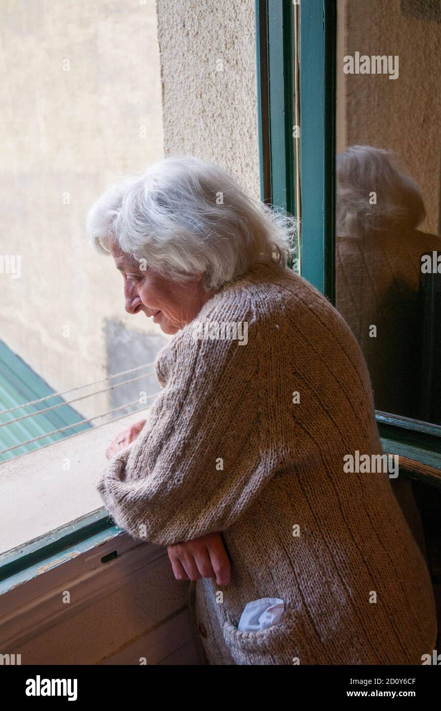 Old lady at the window. Stock Photo