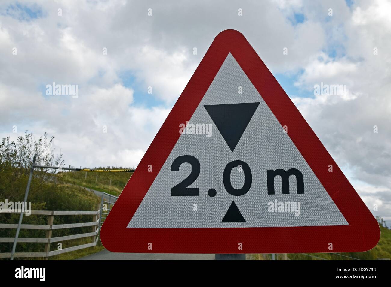 Two metre height restriction sign in red warning triangle with blurred barrier in background. Isle of Skye, Scotland, UK. Stock Photo