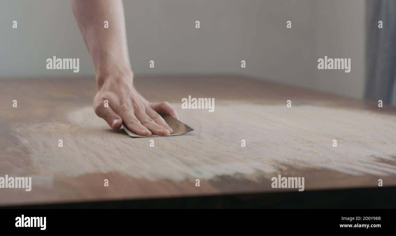 man hand sanding black walnut wood table, wide photo Stock Photo Alamy