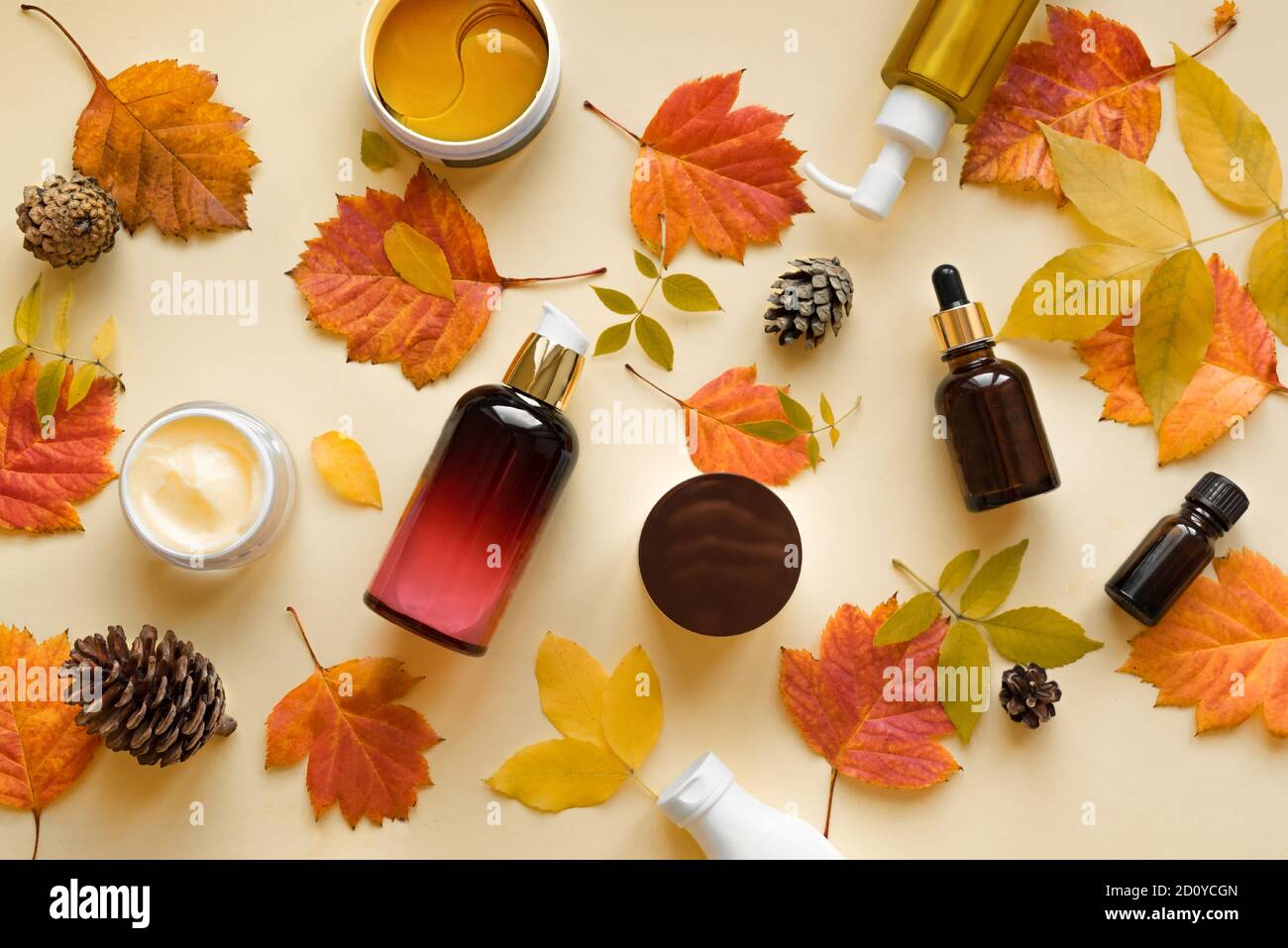 Autumn Skin Care products and autumn leaves on yellow background, flat lay, copy space.  Seasonal beauty routine and organic cosmetic concept. Stock Photo