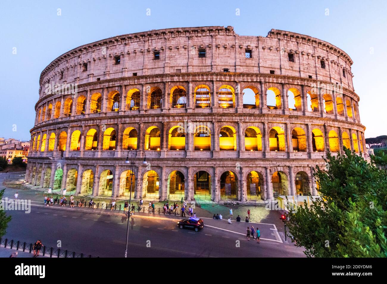 The illuminated Roman Colosseum in rome during the blue hour in the early  evening with the floors lit up by yellow lighting. People in the foreground  Stock Photo - Alamy