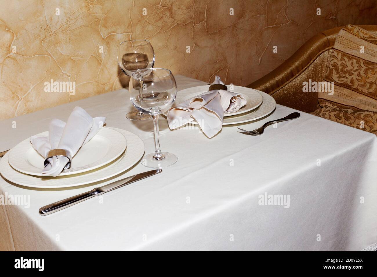 Elegant table setting with fork, knife and white napkin for two persons ...