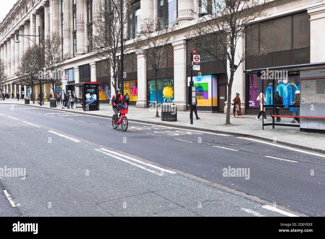 dh  OXFORD STREET LONDON Lack of traffic one lone cyclists riding a bicycle in trafficless city road quiet bike uk Stock Photo