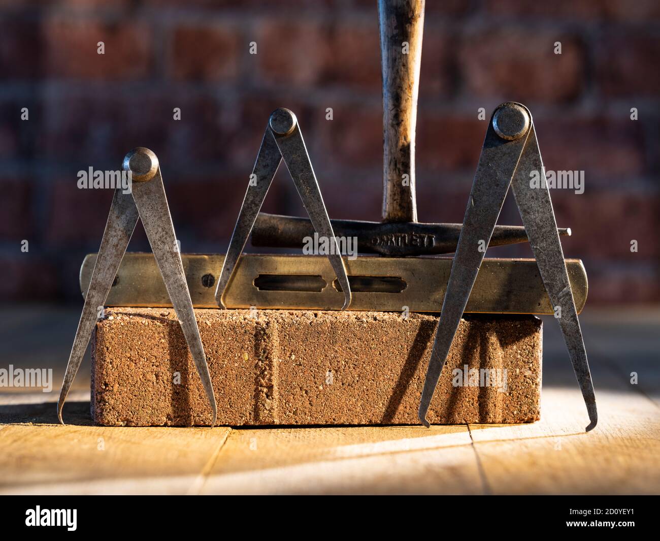Set of three engineers odd leg callipers antique cobblers hammer on timber  flooring resting against red brick & vintage level with brick background  Stock Photo - Alamy