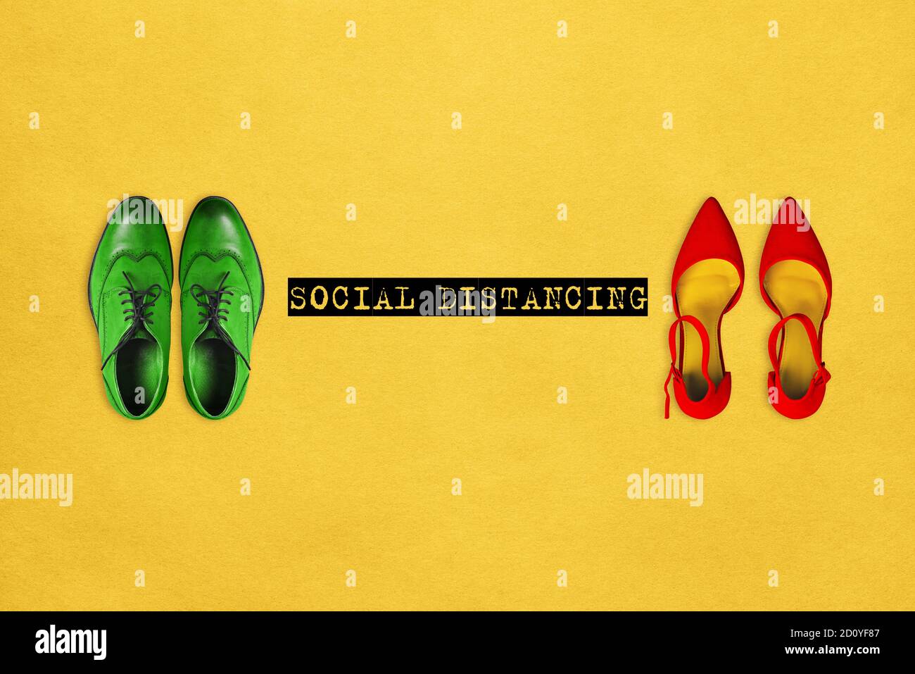 Multi-colored mens and women's shoes on a yellow background with the text Social distancing. The concept of prevention of the risk of infection and Stock Photo