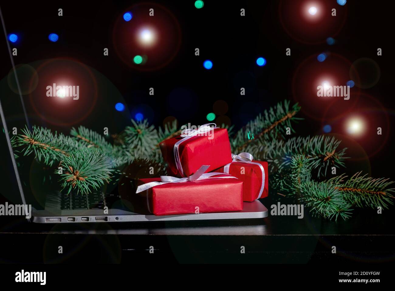 Laptop, Red Gift's Boxes and Christmas Tree on the black background ...