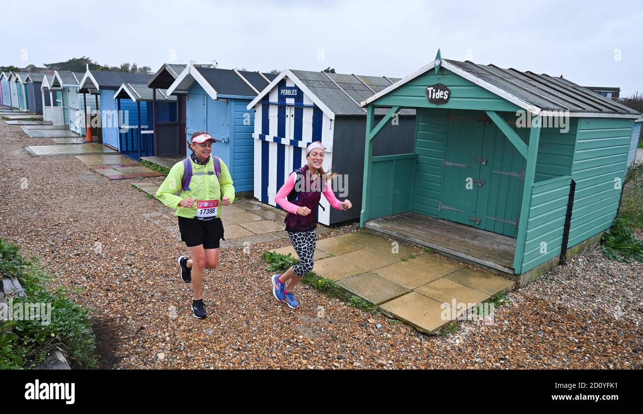 Worthing UK 4th October 2020 -  Runners in the Virtual London Marathon battle against the elements on a wet and windy day along Ferring seafront as they turn for home  back to Worthing as they pass their 20 mile mark : Credit Simon Dack / Alamy Live News . Stock Photo