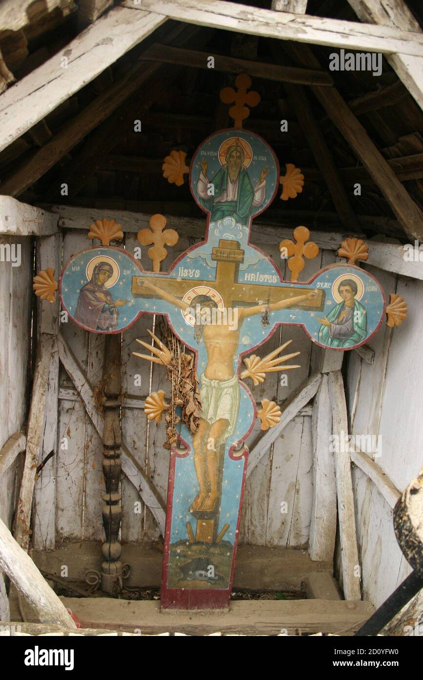 Roadside crucifix in Romania's countryside. Traditionally sculpted wooden  cross, with an image of Jesus Christ crucified Stock Photo - Alamy