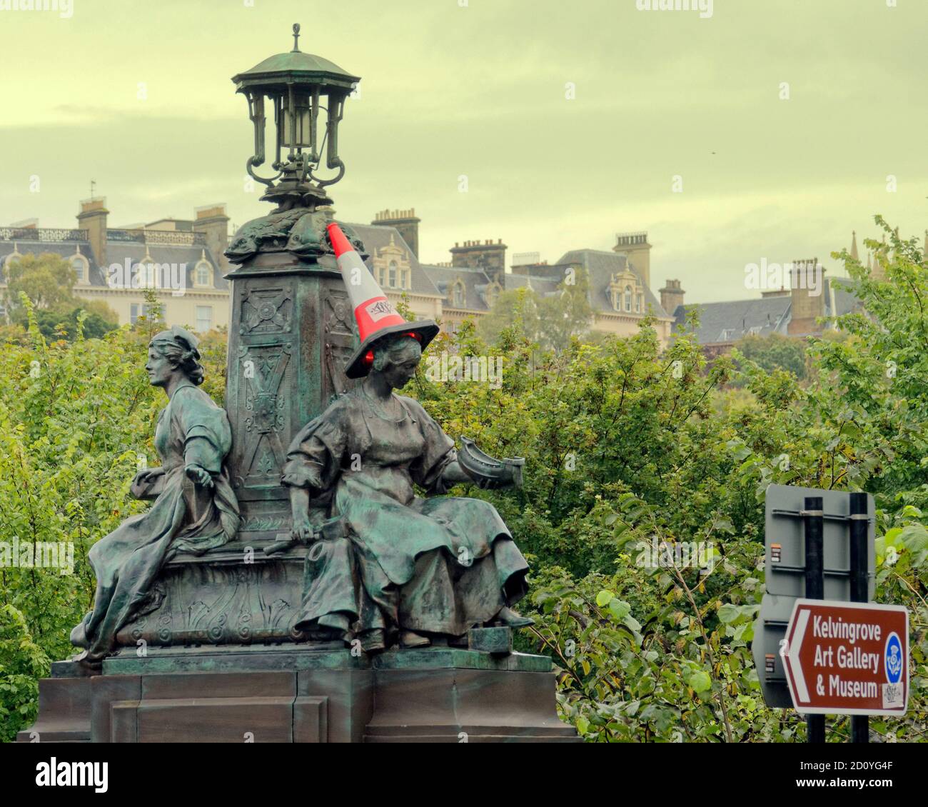 Glasgow, Scotland, UK, 4th October, 2020: UK Weather: Rain and local flooding as Kelvingrove park flooded  and the iconic cone headed man gets a lady as kelvin way bridge as the navigation statue young woman dons a cone. Credit: Gerard Ferry/Alamy Live News Stock Photo