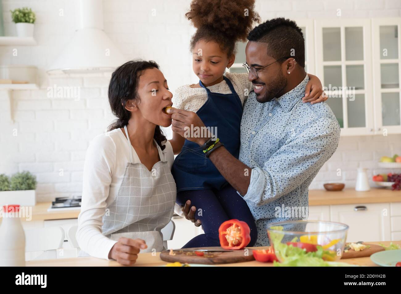 Positive mixed race family entertaining, enjoying cooking together