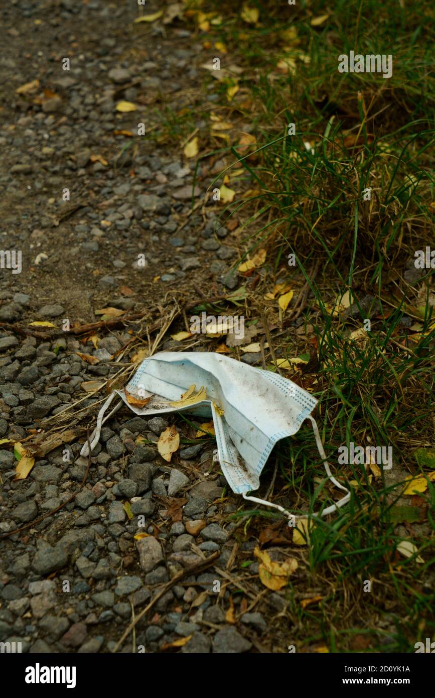 A disposable face mask littering a footpath in the UK Stock Photo Alamy