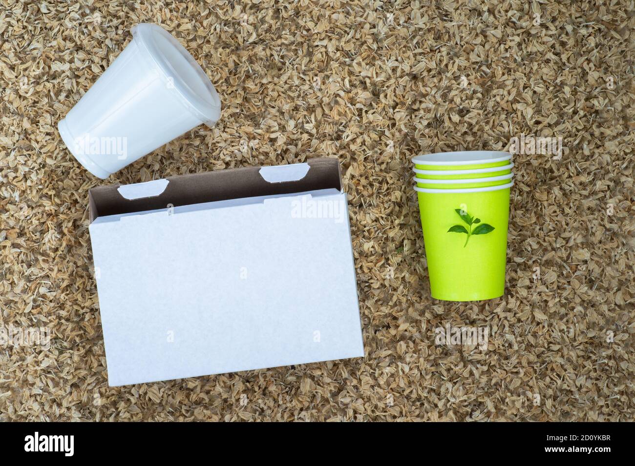 A white cardboard box, a plastic Cup and paper cups with a green sprout ...