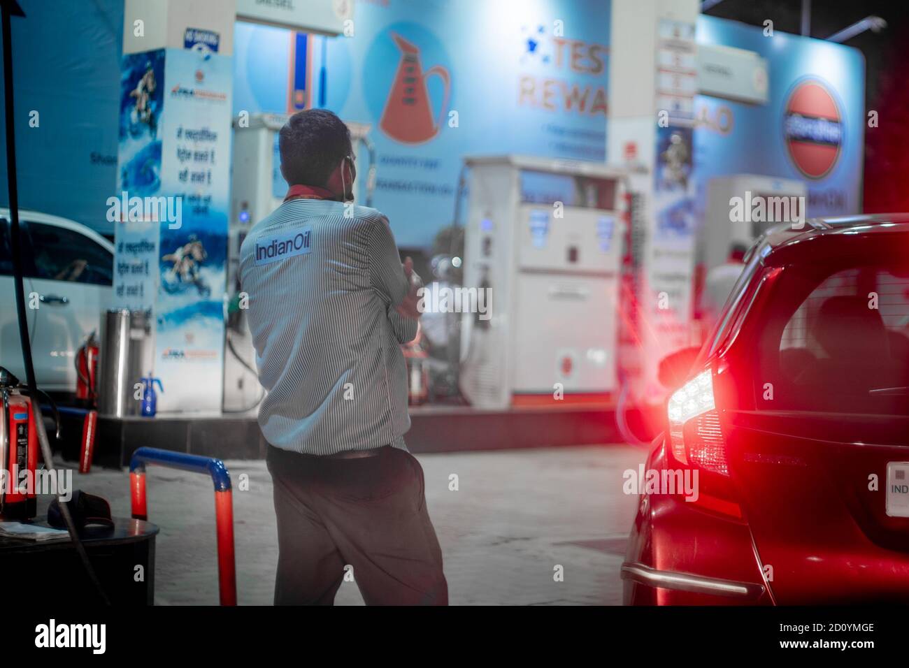 Pump boy completing filling petrol at an indian oil petrol pump in a