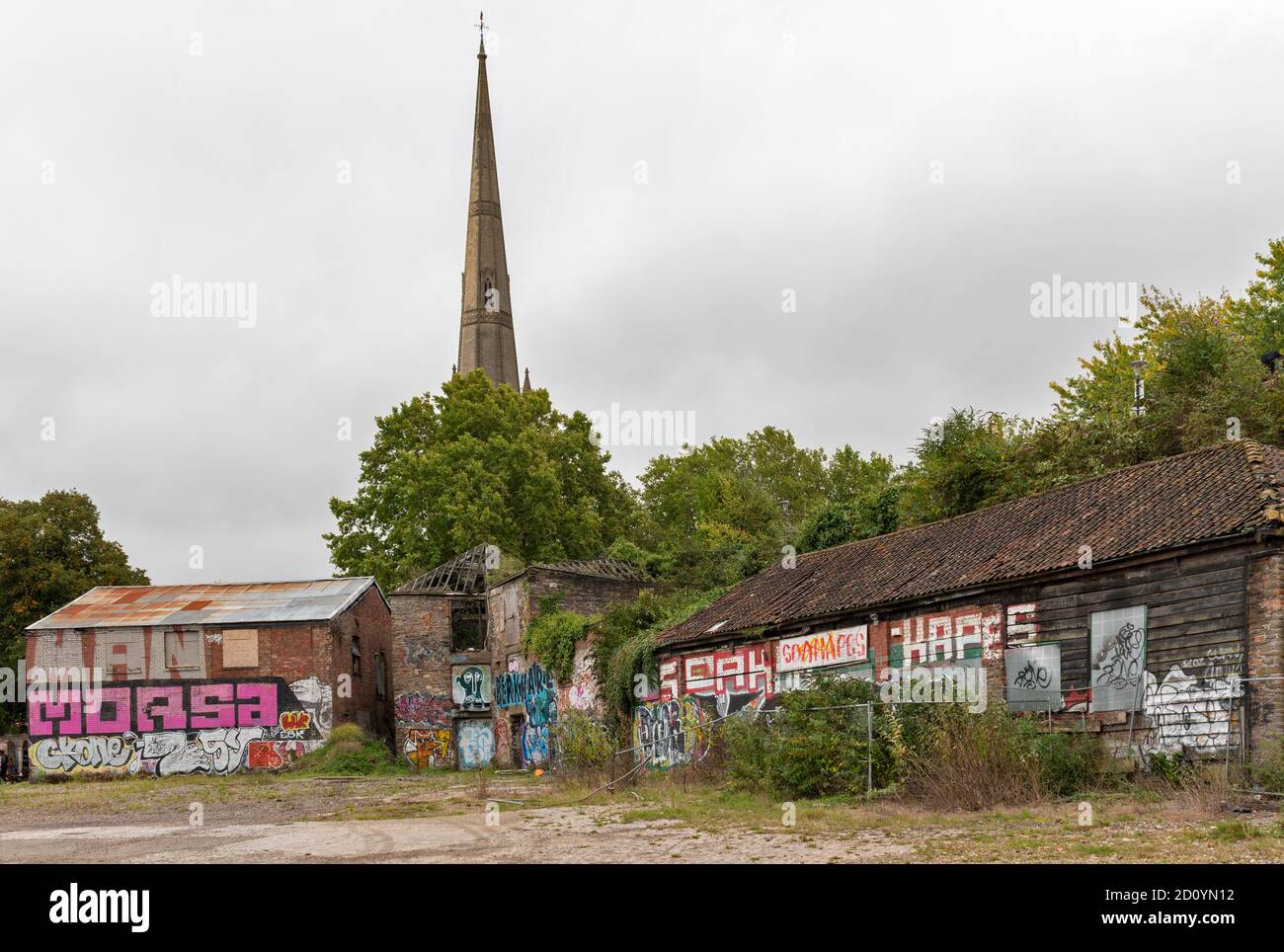 BRISTOL CITY ENGLAND THE STEEPLE OF ST.MARY REDCLIFFE CHURCH AND GRAFFITI ART ON THE OLD BUILDINGS AND WALLS Stock Photo