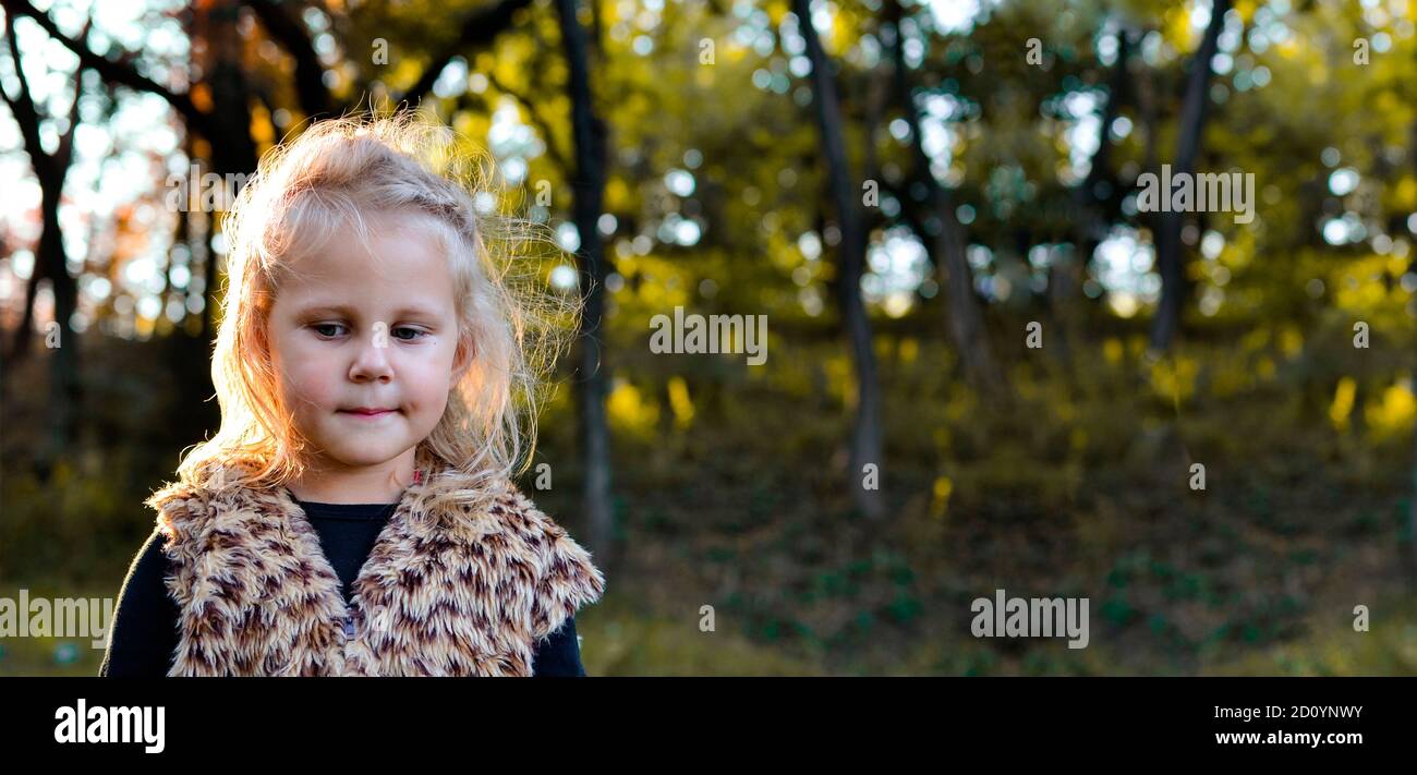 Child portrait, close-up. Girl outdoors in nature. Beautiful girl 3 years old. Autumn photo. Children's emotions. Free space for text Stock Photo