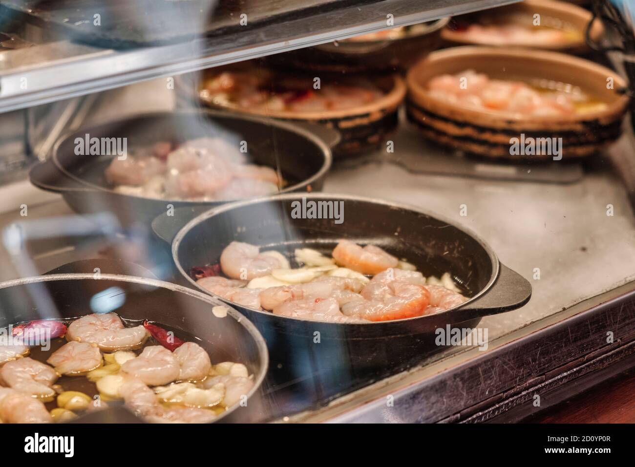 Benidorm, Alicante Province, Spain October 5, 2019, „Gambas al Ajillo“, Tapas in the showcase of the tapas bar 'Cava Aragonesa' in the Calle Santo Domingo in the old town Stock Photo