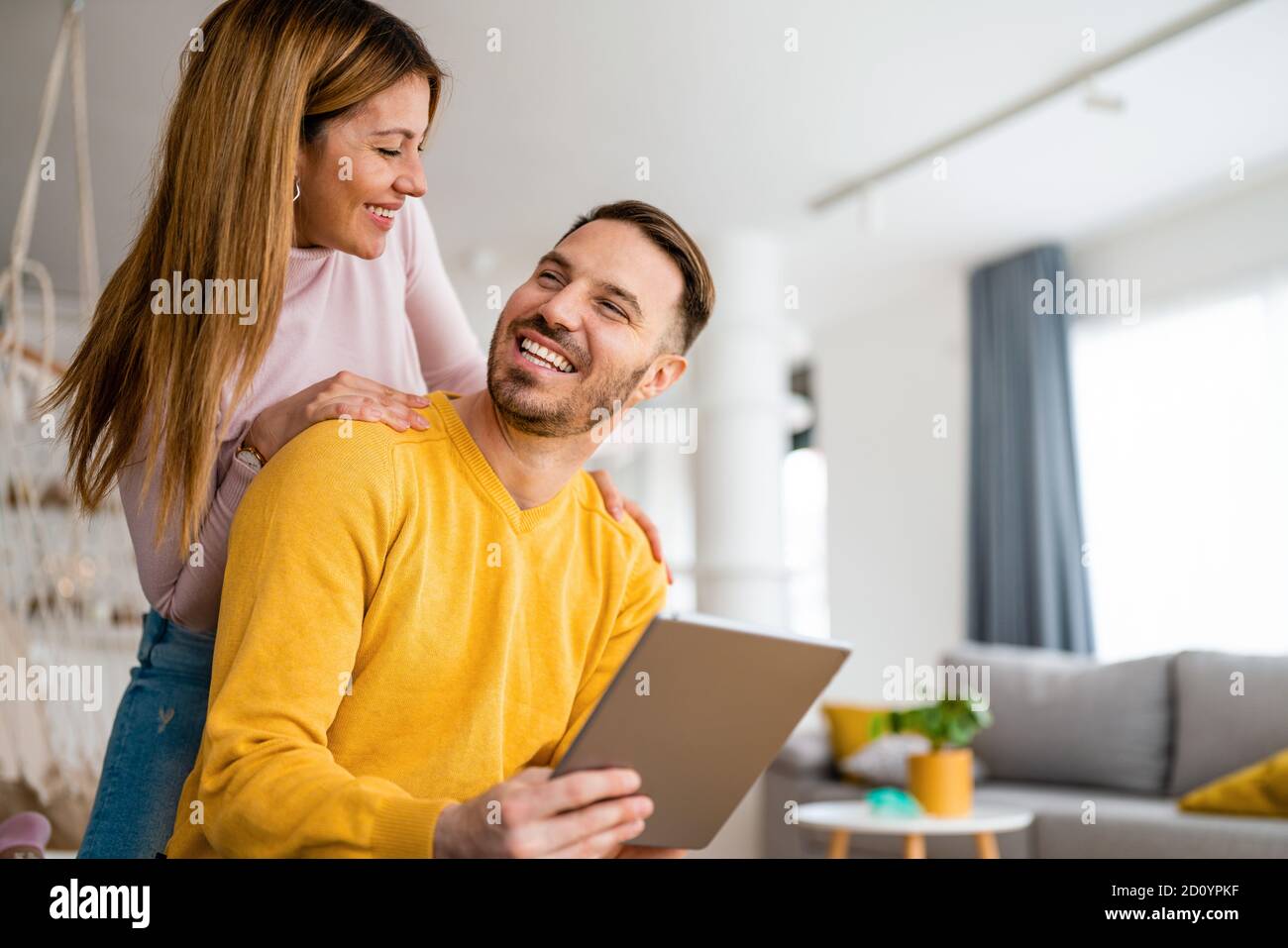 Couple in love hugging and using tablet together. Stock Photo