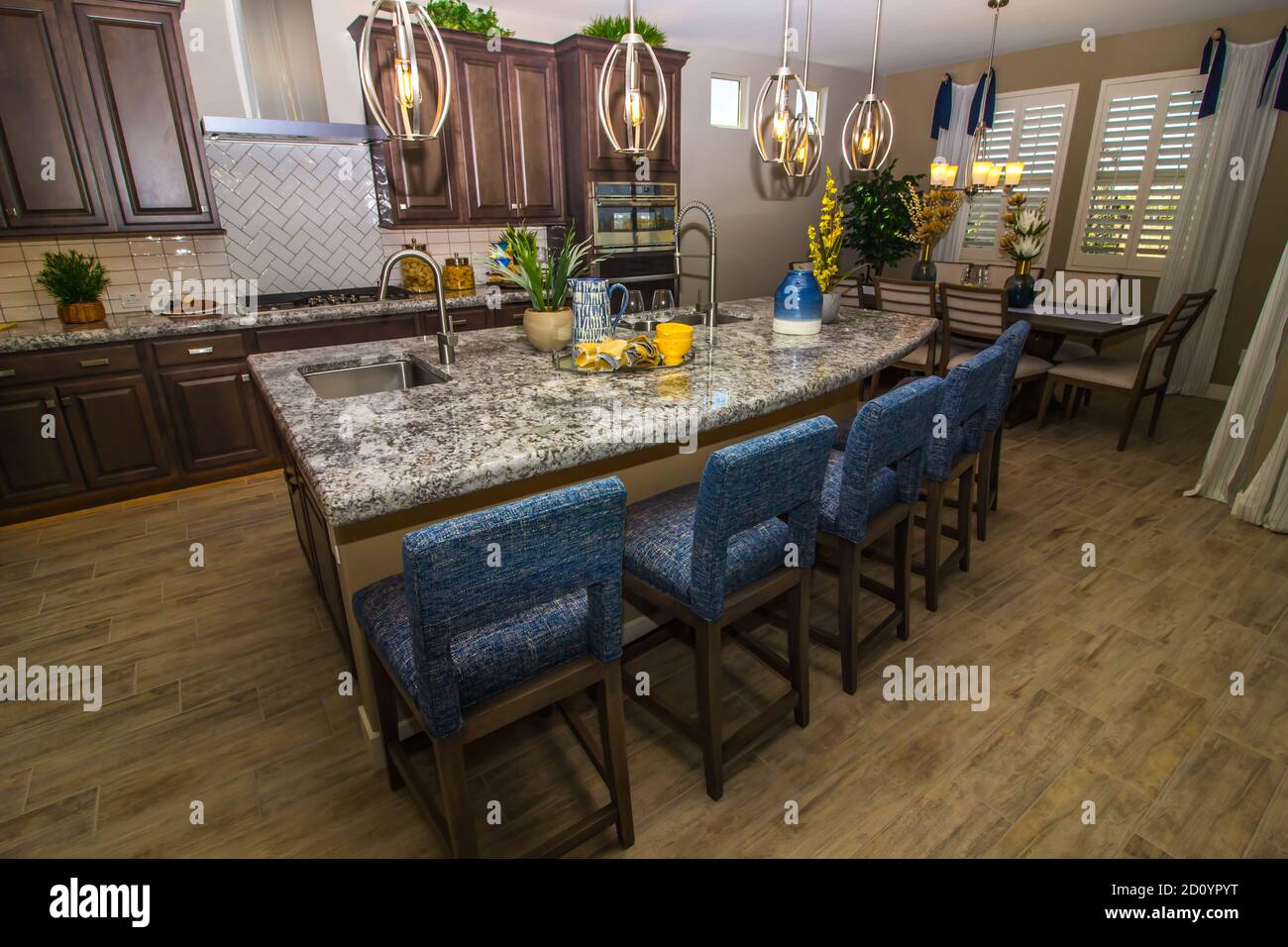 Granite Kitchen Island With Counter Bar Stools And Separate Dining Area Stock Photo