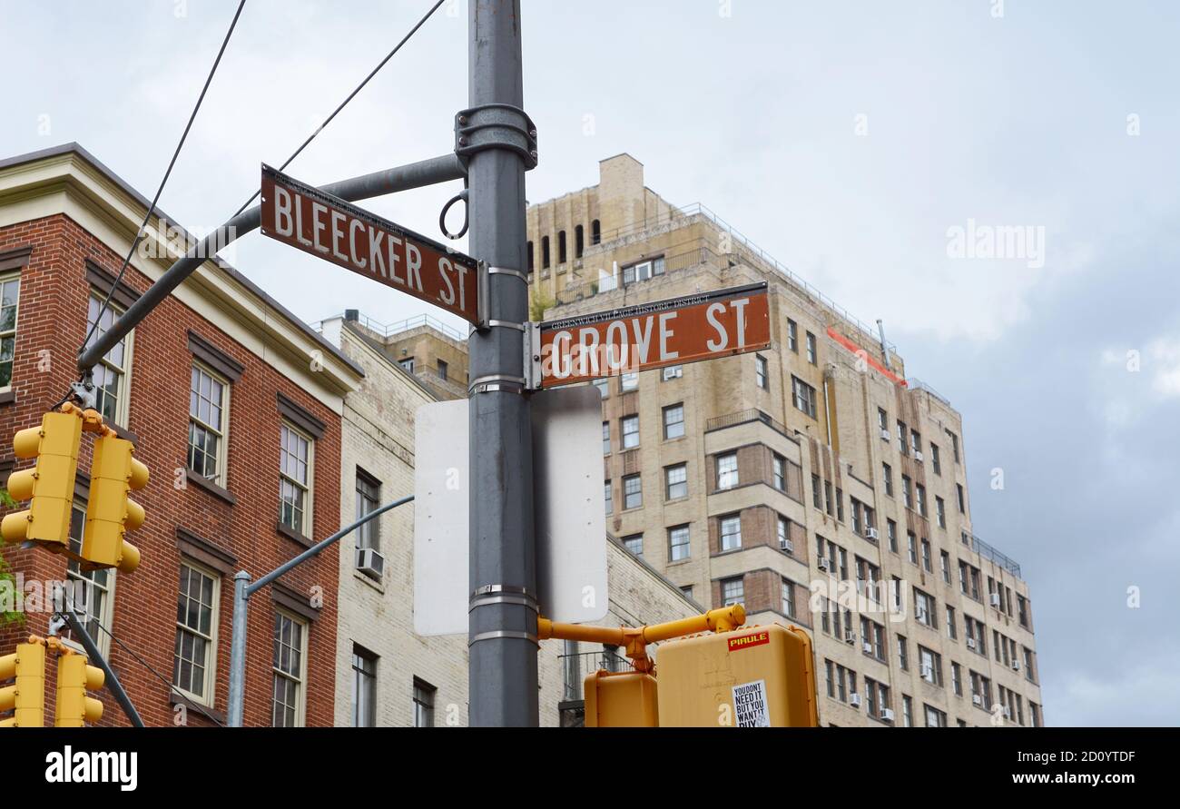 Street signs in New York City for Bleecker Street and Grove Street on a traffic light pole. Apartment buildings beyond. Stock Photo