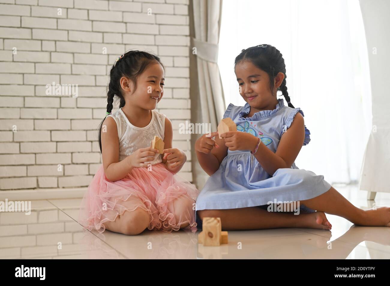 Two children with toy blocks at home or daycare. Stock Photo
