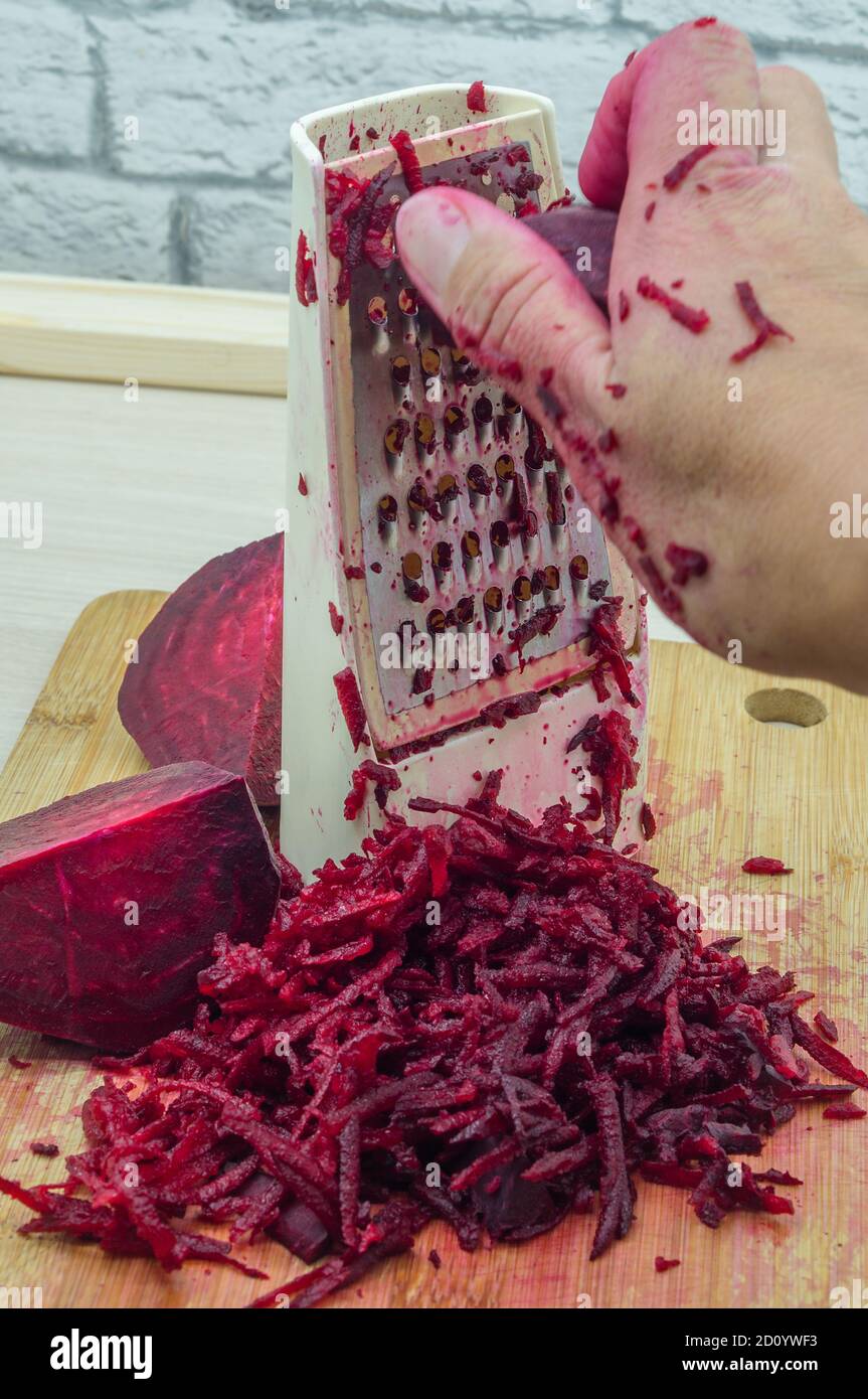 grate beetroot on a grater, fresh beet grated Stock Photo