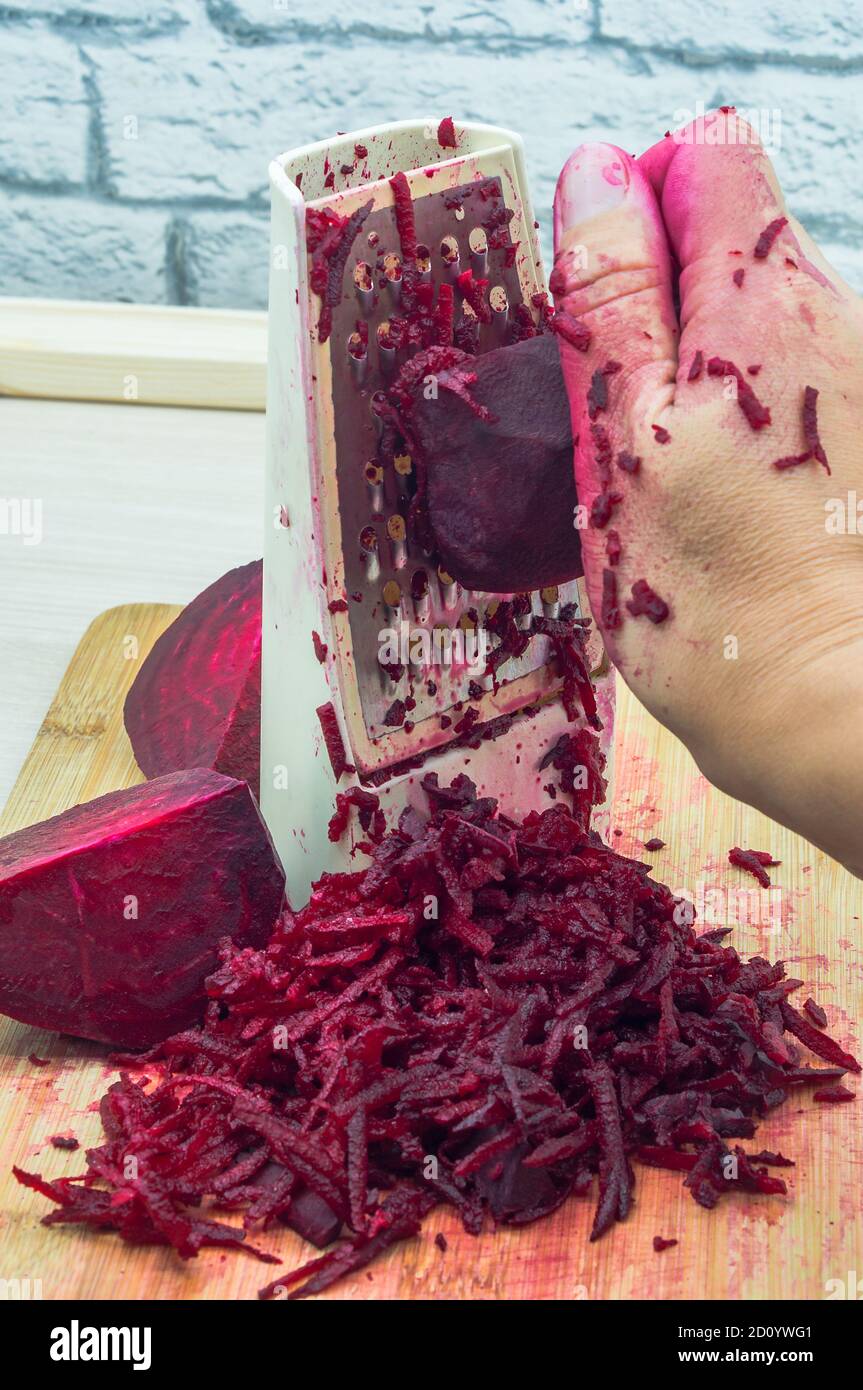 grate beetroot on a grater, fresh beet grated Stock Photo