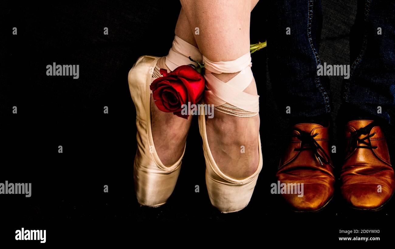 Leather dressed cognac brown shoes on dark blue jeans and ballerina shoes  with red rose Stock Photo - Alamy