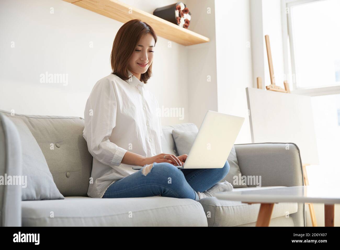 young asian business woman working at home sitting on couch using ...