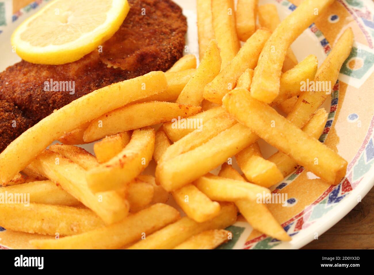 French fries and a wiener schnitzel with lemon on a plate Stock Photo