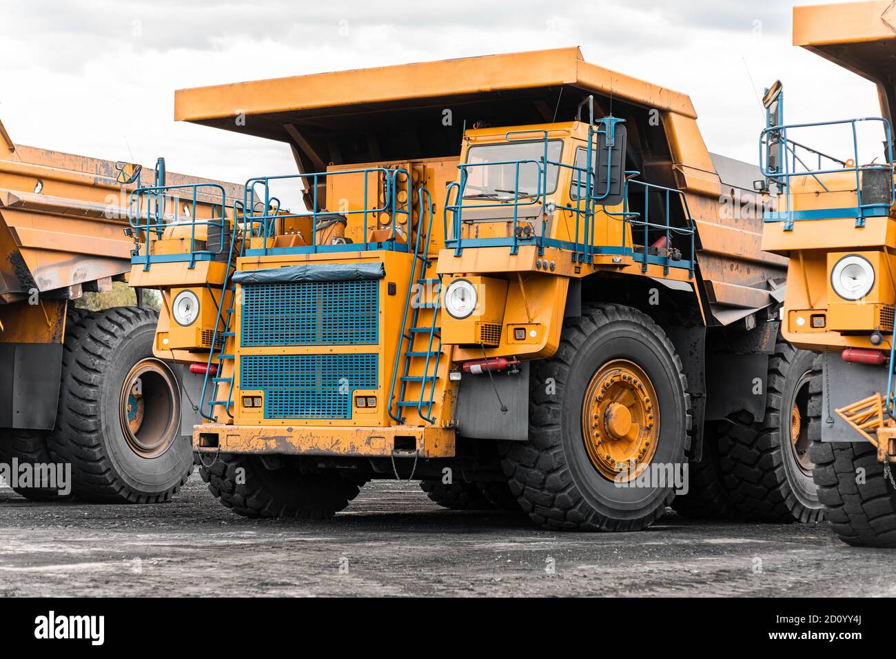 Large quarry dump truck. Big yellow mining truck at work site. Loading