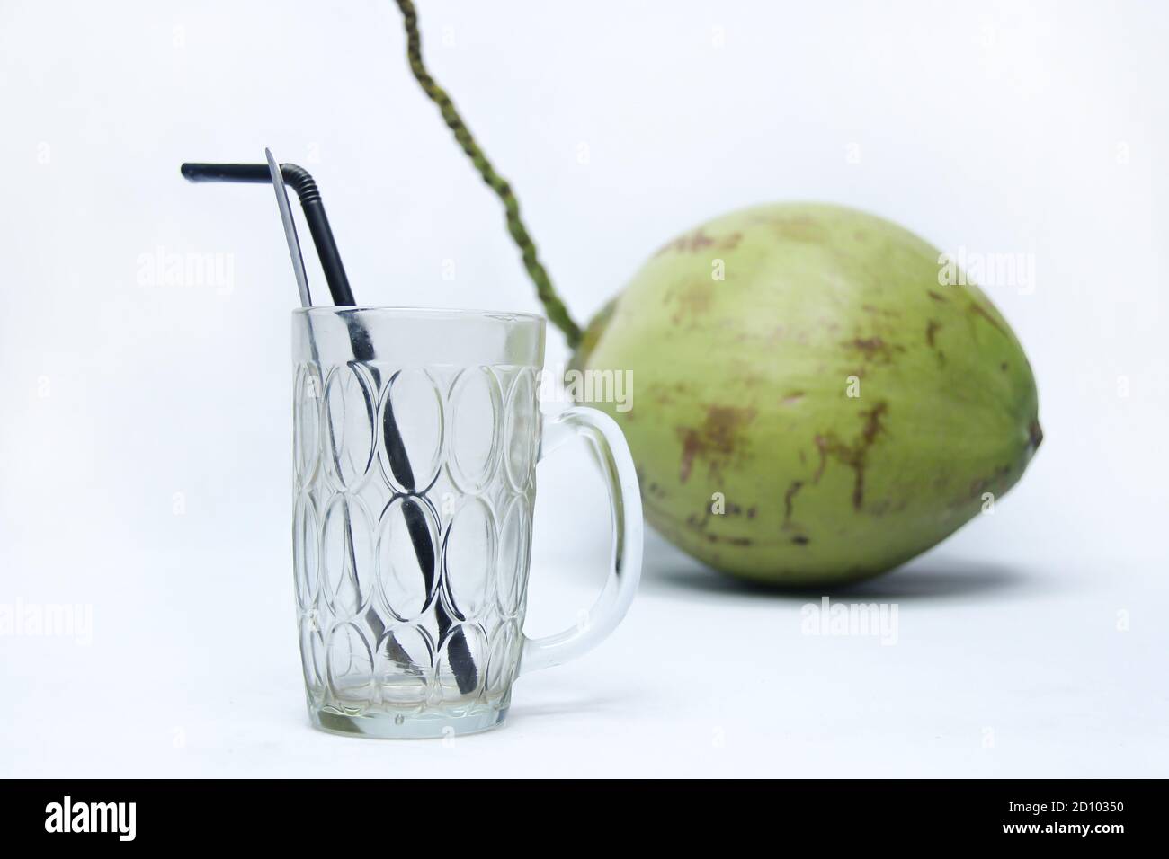 empty glass with green coconut isolated on white background. natural fresh drink Stock Photo
