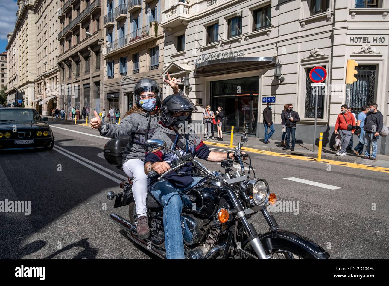 Barcelona, Spain. 04th Oct, 2020. A motorcyclist wearing a mask is seen  raising his hand in victory while riding his motorcycle without an  eco-label during the demonstration.Demonstration of drivers and vehicles  affected