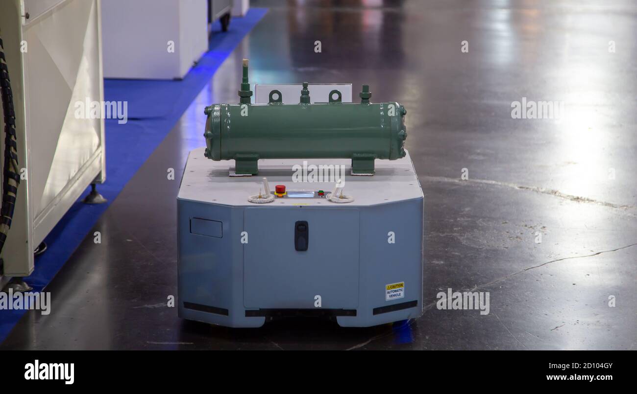 Automated robot handling product in smart factory. AGV Automatic Guided Vehicle transporting equipment in modern warehouse. Stock Photo