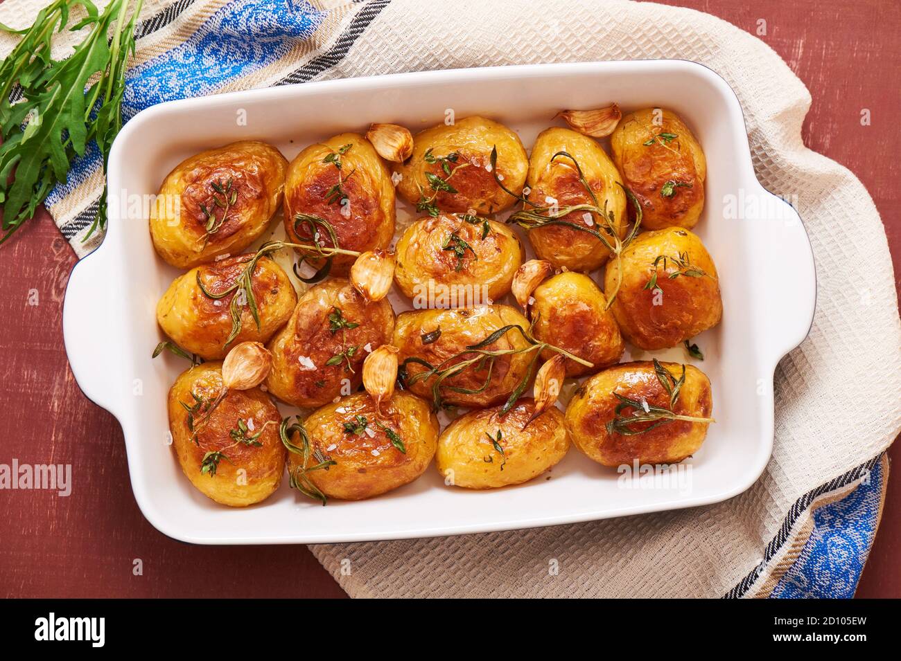 Roasted potatoes with garlic, thyme and rosemary in ceramic baking dish