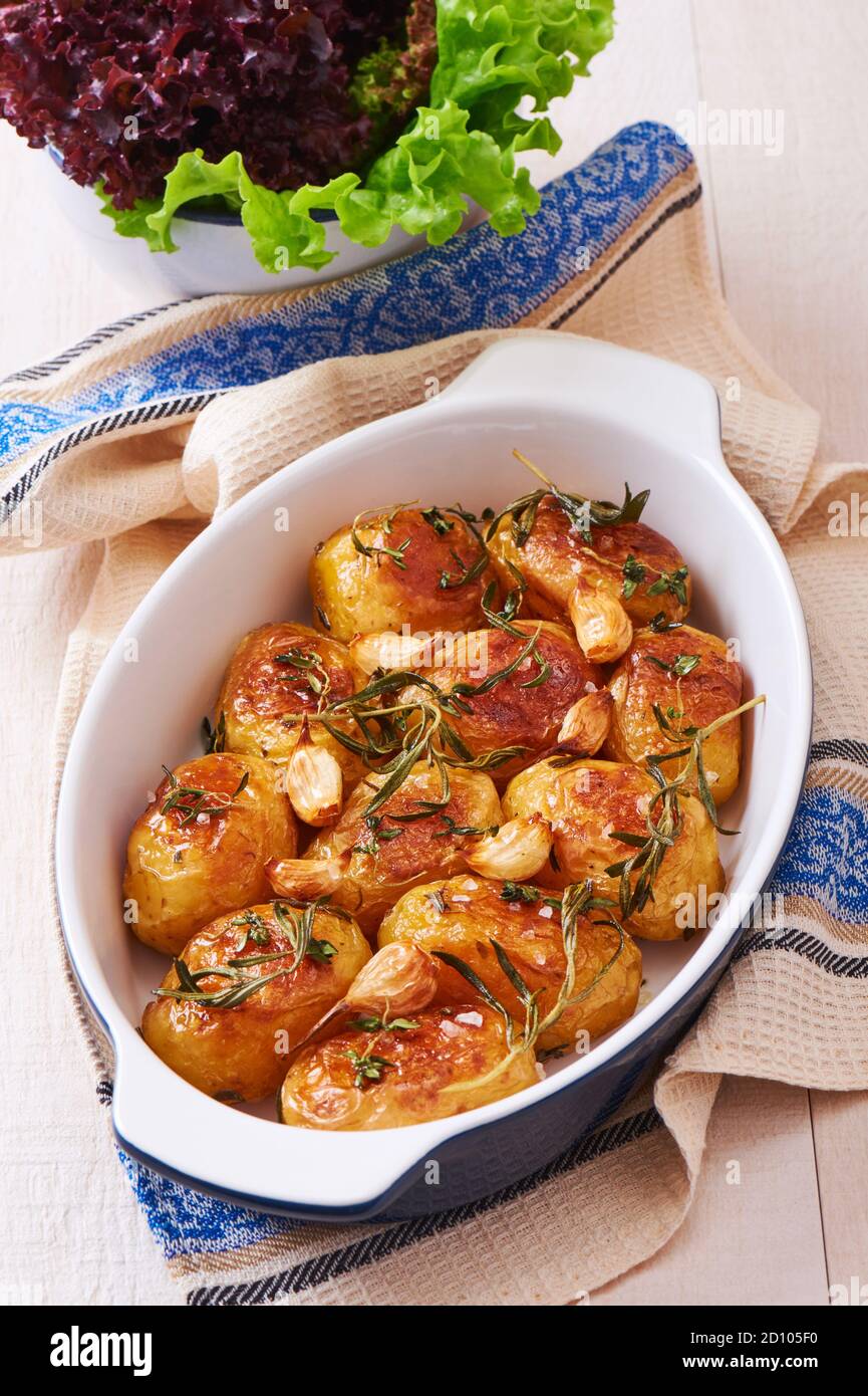 Roasted potatoes with garlic, thyme and rosemary in ceramic baking dish