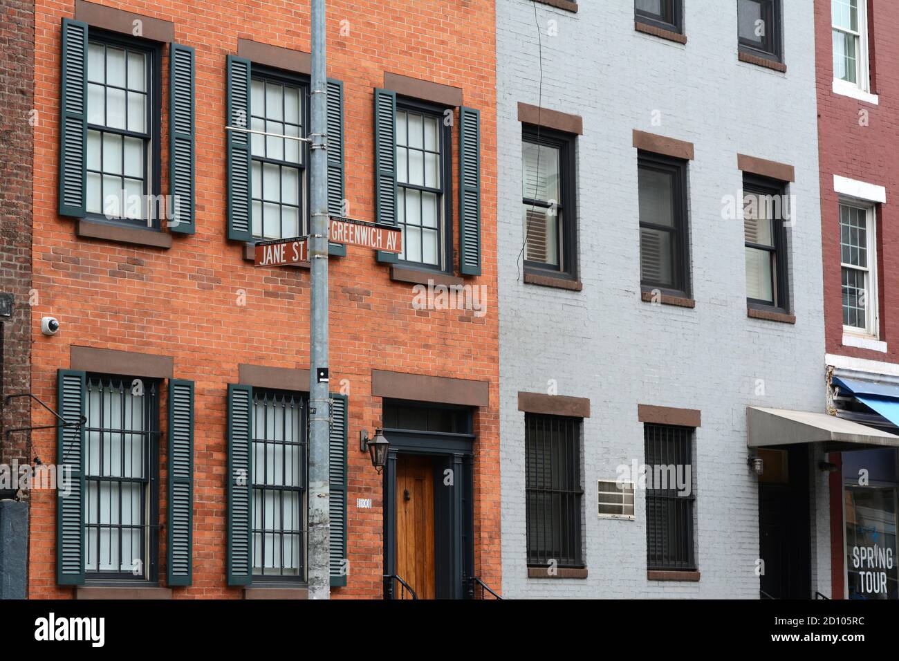 NEW YORK, USA - MAY 10, 2019: Street signs on corner of Greenwich Avenue and Jane Street in front of an attractive red brick townhouse in New York Cit Stock Photo