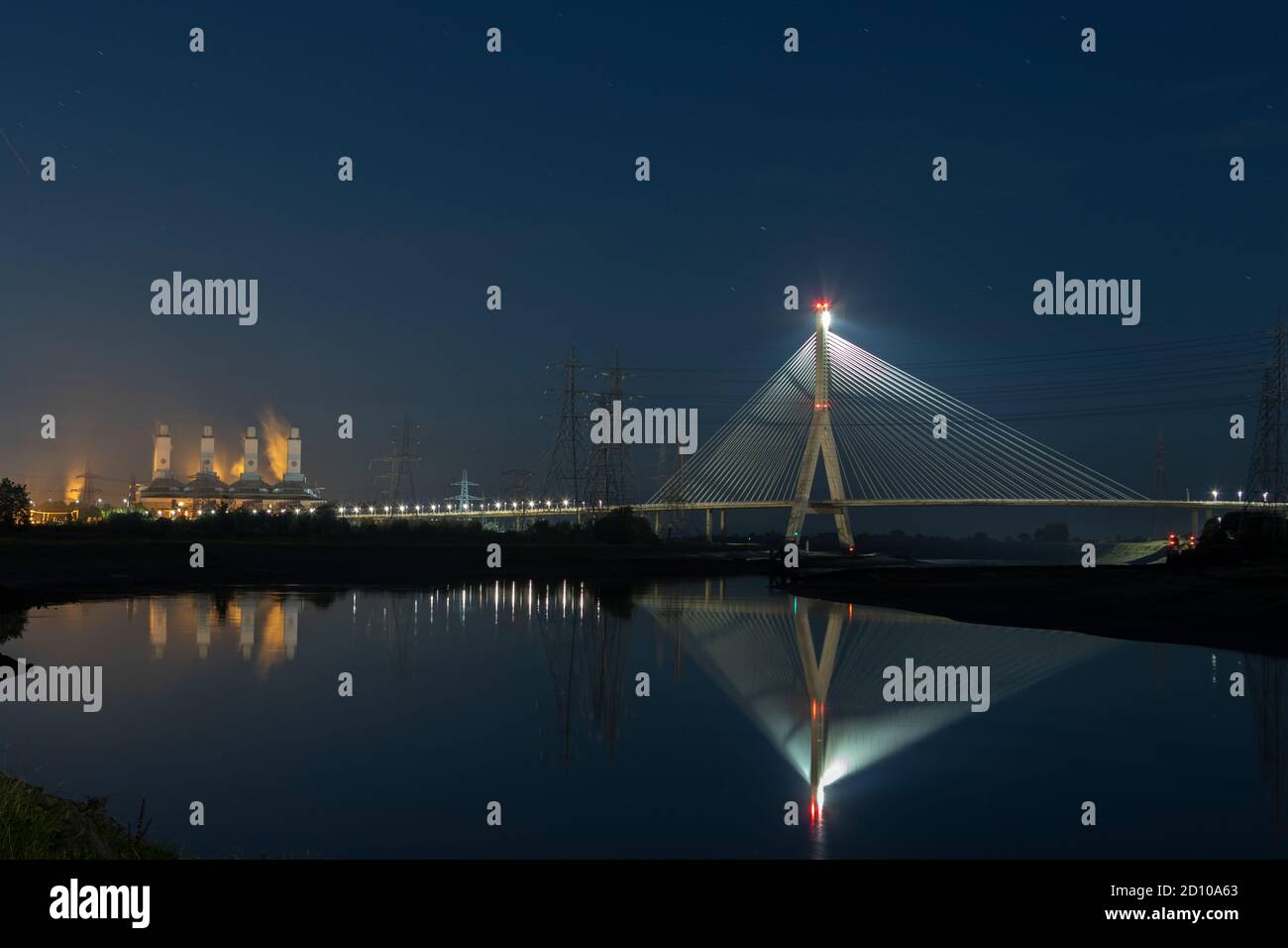 Cable-stayed Flintshire Bridge,lit at night, spanning River Dee linking Flint and Wirral Peninsula. Connah's Quay Gas Power Station to the South West Stock Photo