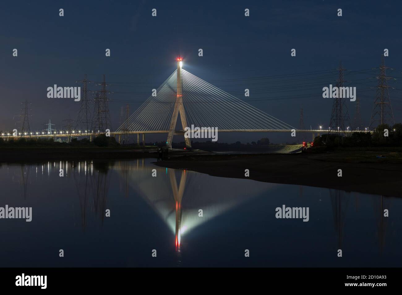 Cable-stayed concrete Flintshire Bridge,lit at night, spanning River Dee viewed from Connah's Quay. Fan like structure reflected in mirrored Estuary Stock Photo
