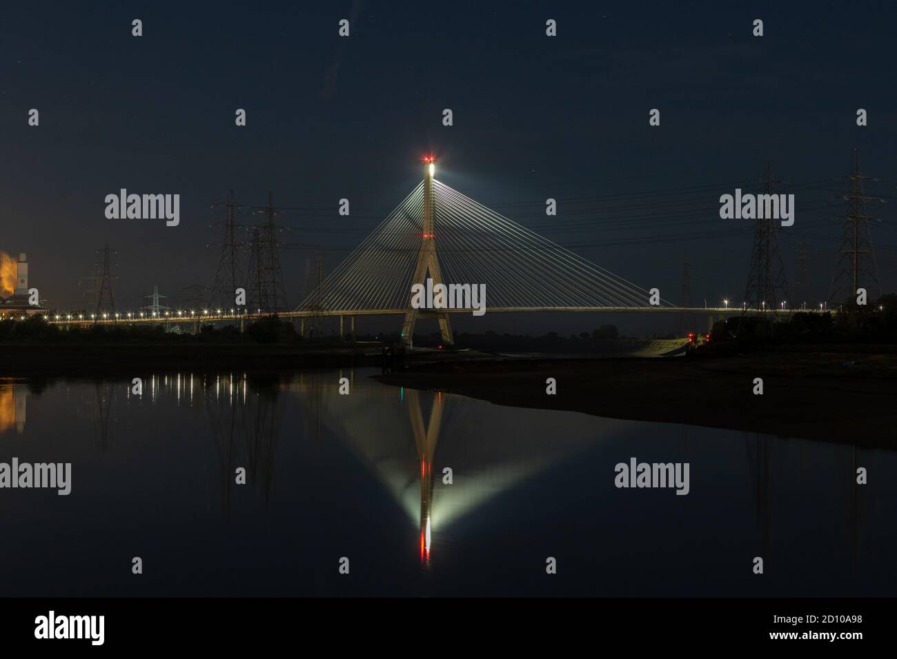 Cable-stayed concrete Flintshire Bridge,lit at night, spanning River Dee viewed from Connah's Quay. Fan like structure reflected in mirrored Estuary Stock Photo