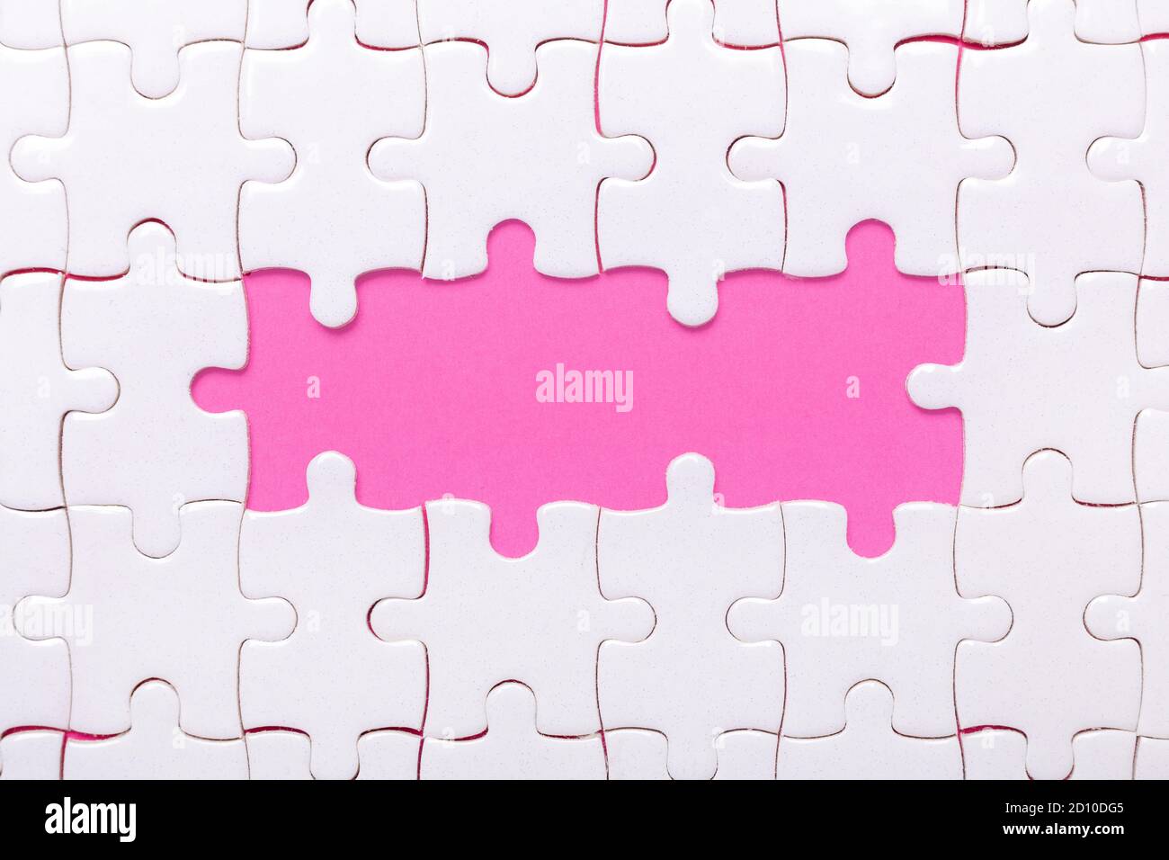 White jigsaw puzzle with empty space for text and pink background - Image Stock Photo