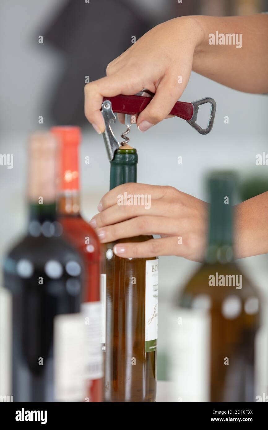 hands opening bottle of wine with corkscrew Stock Photo Alamy