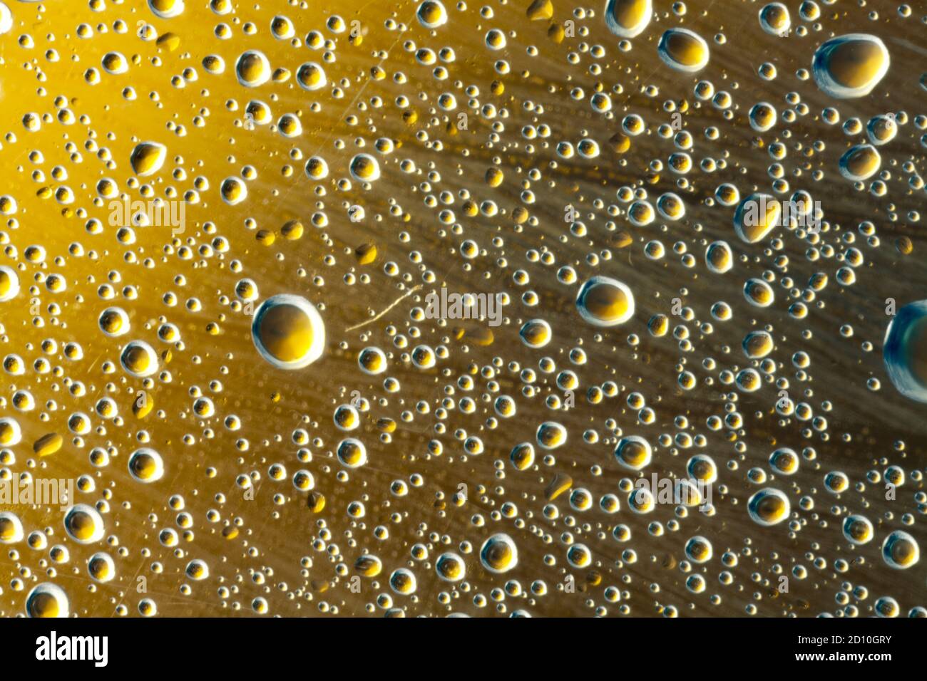 Droplets of sprayed water refracting the yellow light of a lemon ...