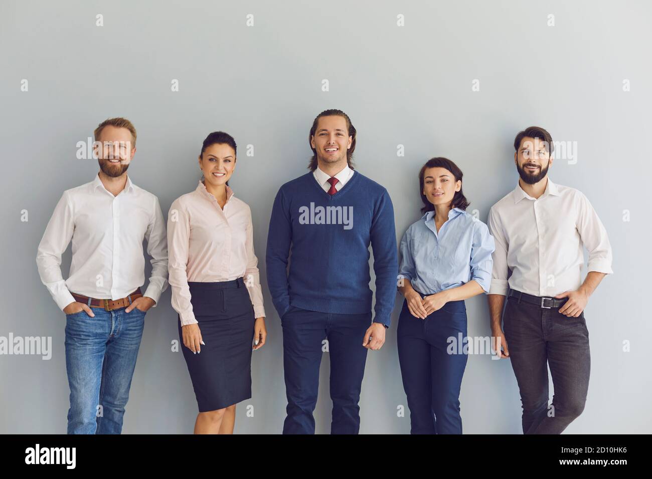 Group portrait of smiling young entrepreneurs or company workers looking at camera Stock Photo