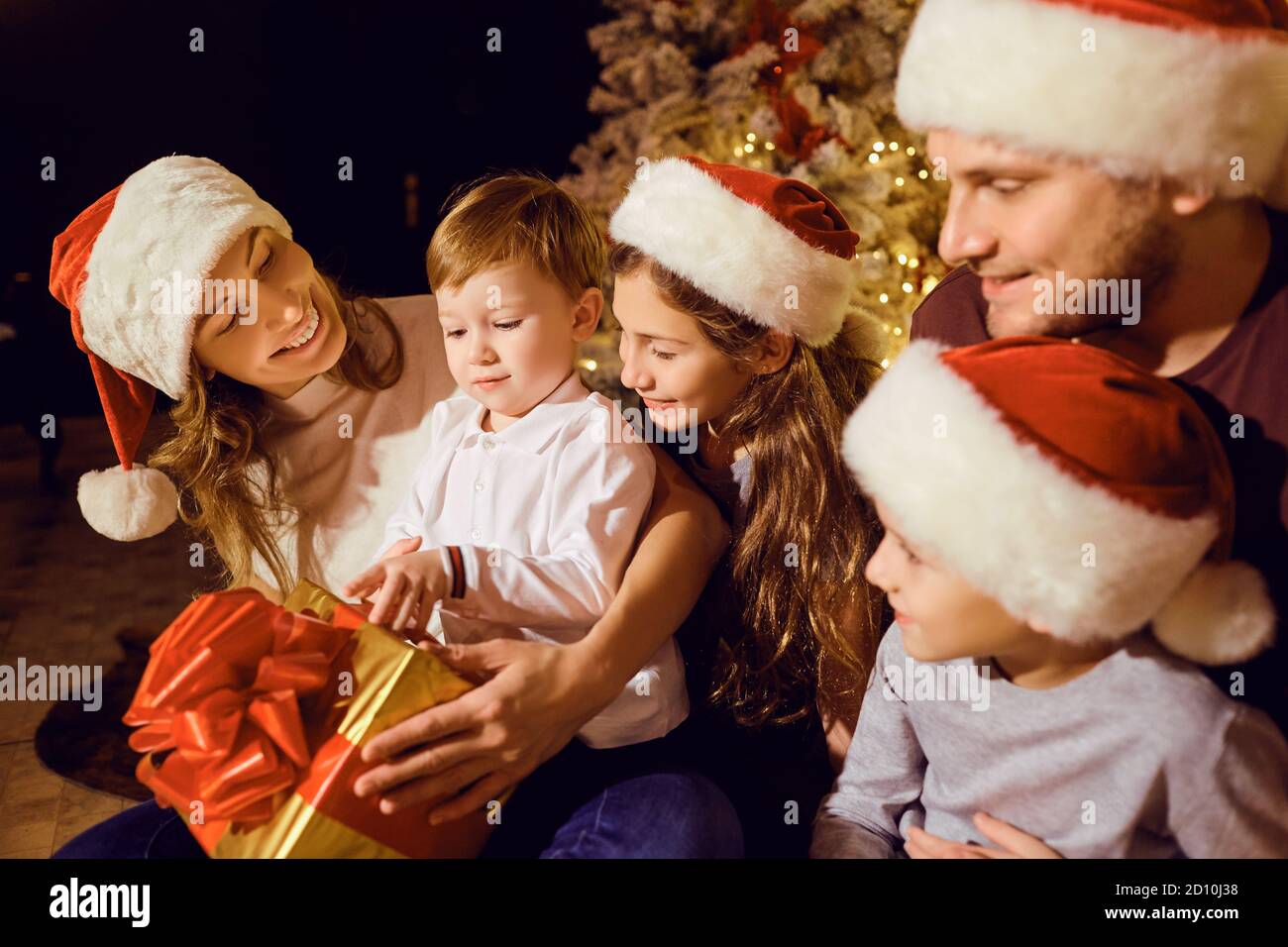 Happy family gives gifts to children in a room at Christmas Stock Photo