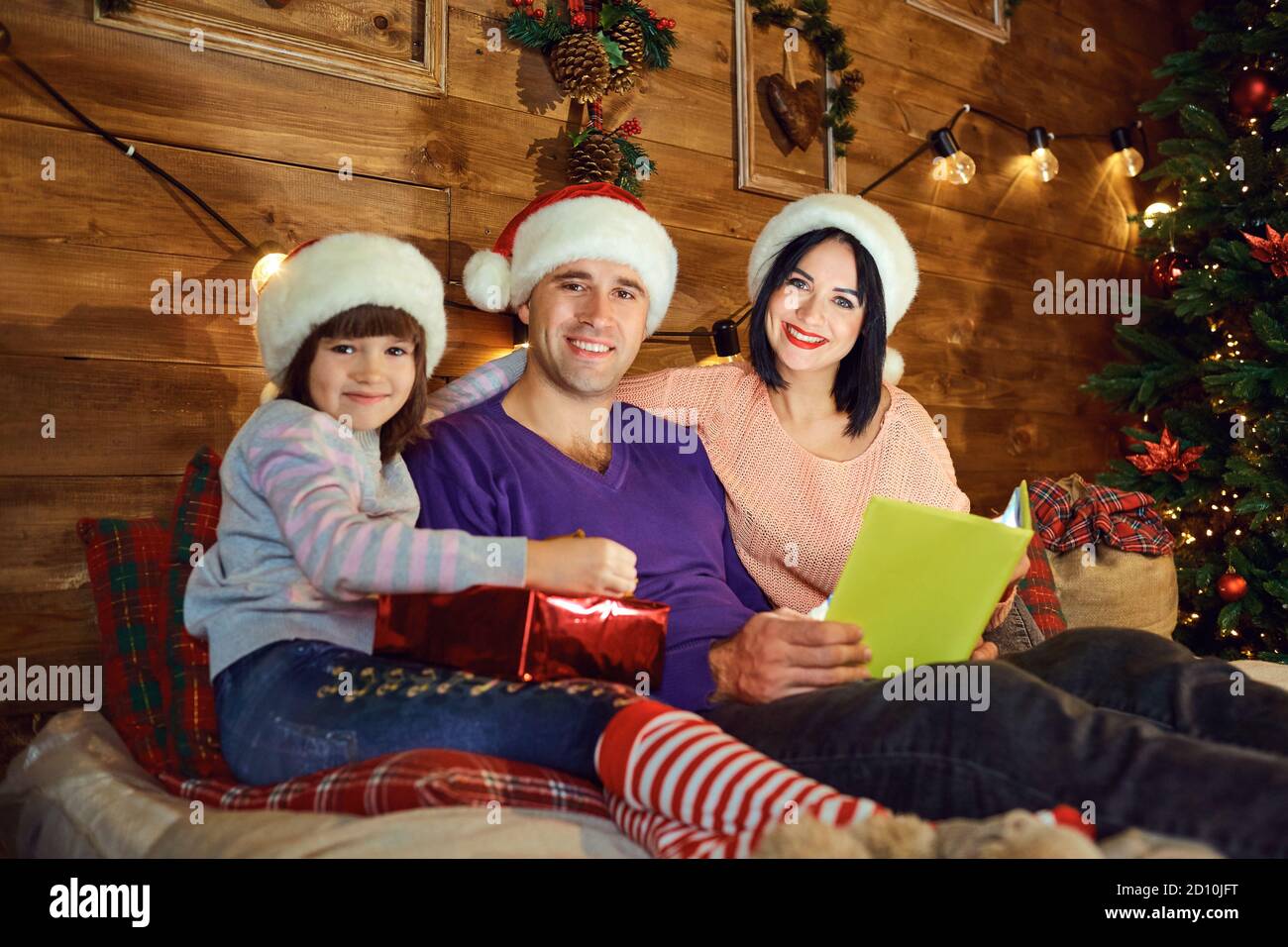 Family is reading a book in a room in Christmas. Stock Photo